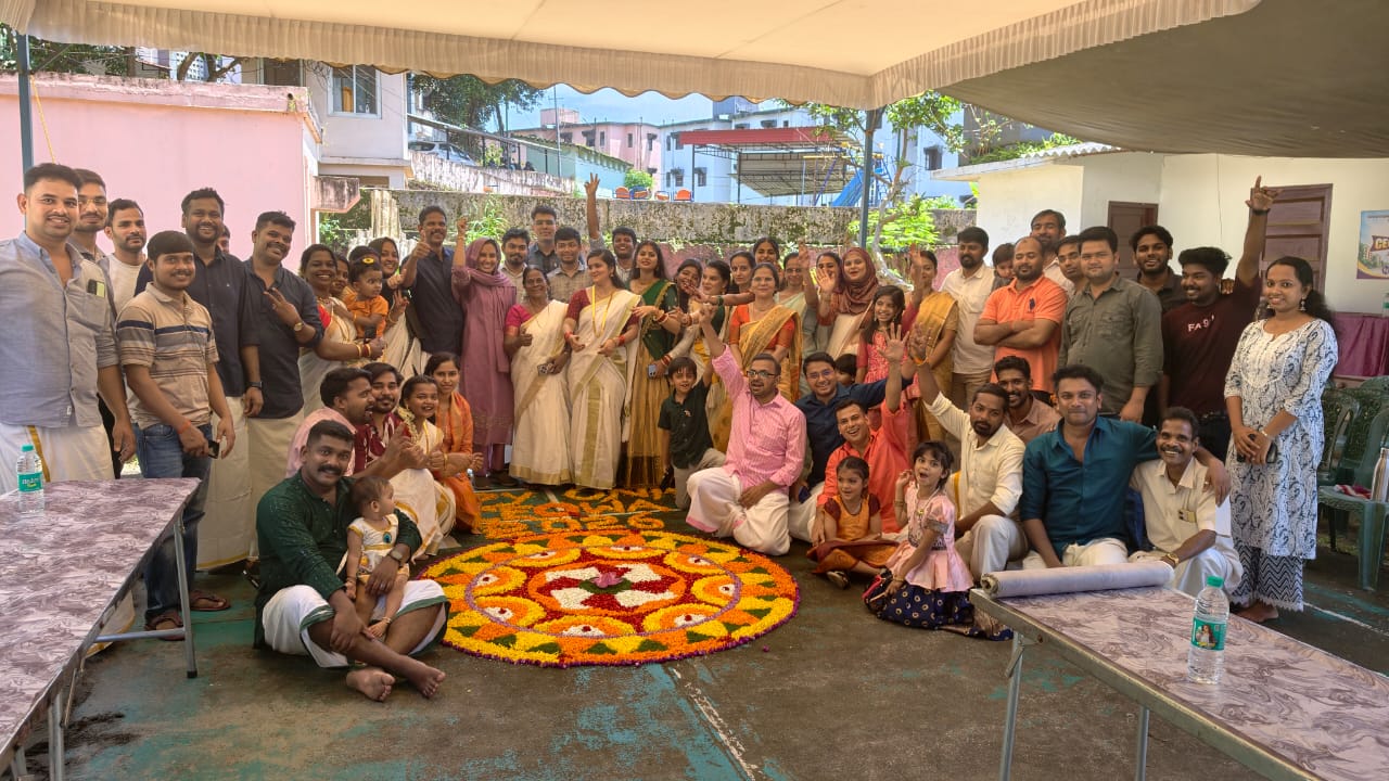 CEQWA residents and families gathered around a floral pookalam during the Onam celebration